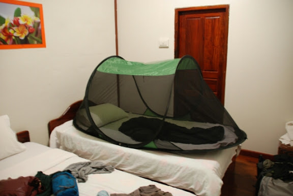 SansBug mosquito net tent on a twin bed in a guesthouse in Laos